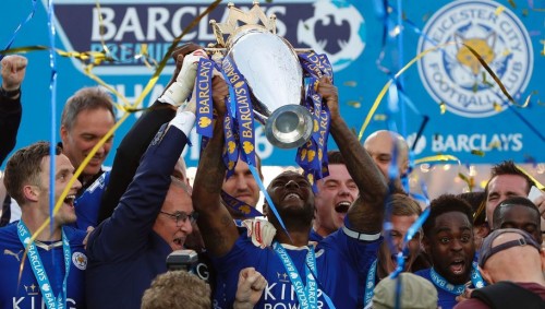 Leicester City's Italian manager Claudio Ranieri (2L) and Leicester City's English defender Wes Morgan hold up the Premier league trophy after winning the league and the English Premier League football match between Leicester City and Everton at King Power Stadium in Leicester, central England on May 7, 2016. / AFP / ADRIAN DENNIS / RESTRICTED TO EDITORIAL USE. No use with unauthorized audio, video, data, fixture lists, club/league logos or 'live' services. Online in-match use limited to 75 images, no video emulation. No use in betting, games or single club/league/player publications. / (Photo credit should read ADRIAN DENNIS/AFP/Getty Images)